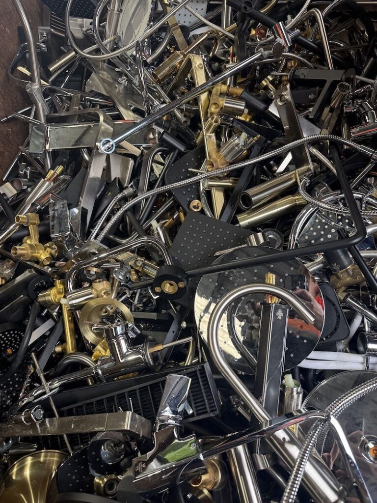 Bin of scrap brass and chrome tapware, mixers and shower heads at Malaga Scrap Metal