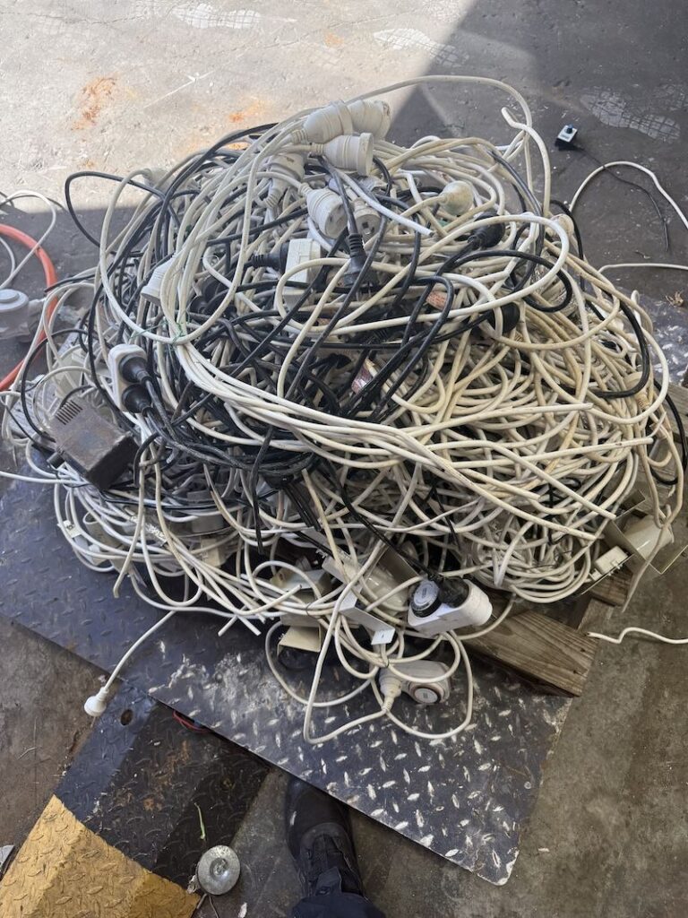 Pile of old extension leads and power cords ready for recycling at Malaga Scrap Metal